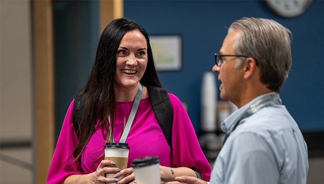 Two employees chatting over coffee